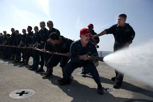 Several people holding a firehose